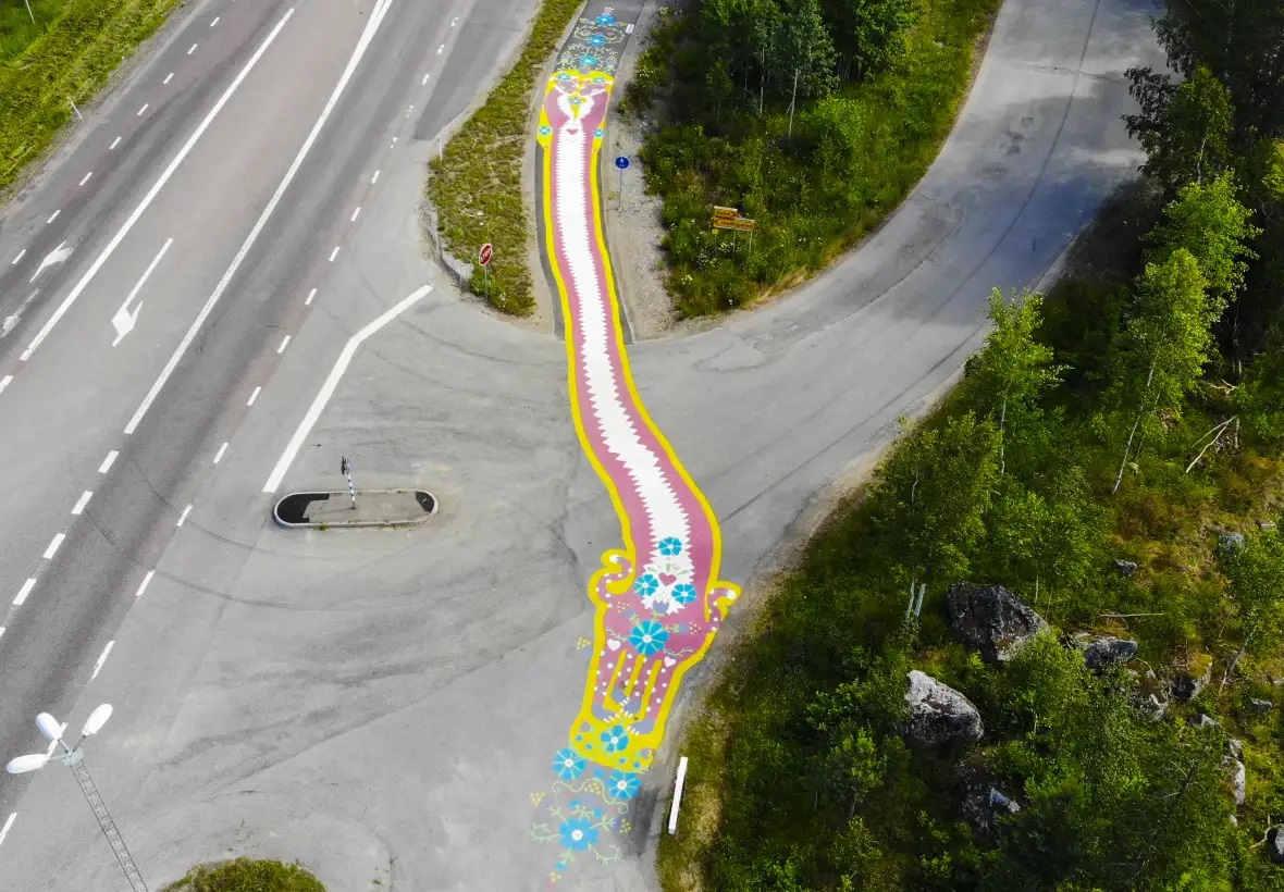 drönarbild ovanifrån på 30 meter långt målat konstverk på cykelväg som löper bredvid och över bilväg